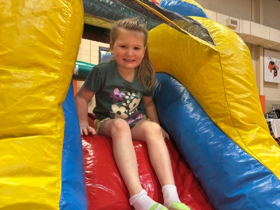 A child enjoying a colorful inflatable slide