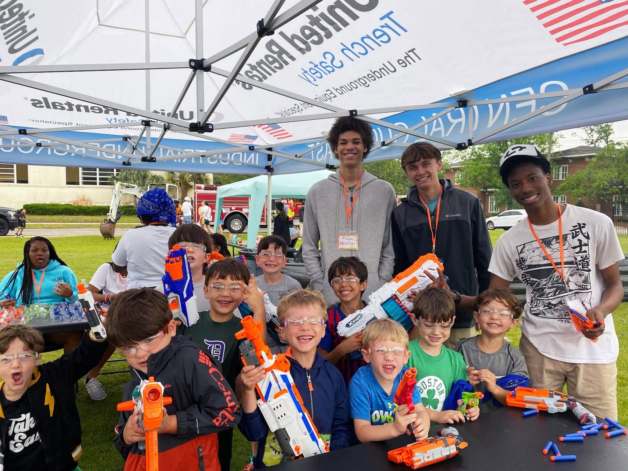Children posing with foam dart blasters at a community play event
